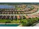 Overhead view of a neighborhood featuring well-kept lawns, mature trees, and walking paths around a picturesque pond at 11611 Callisia Dr, Odessa, FL 33556