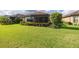 View of the perfectly manicured back yard with vibrant green grass and screened-in patio at 11611 Callisia Dr, Odessa, FL 33556