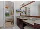 This bathroom features granite countertops, a TV, and a view into the main bedroom at 11611 Callisia Dr, Odessa, FL 33556