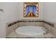An oval bathtub sits below a stained glass window and is surrounded by decorative tile at 11611 Callisia Dr, Odessa, FL 33556