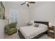 This light and bright bedroom features a ceiling fan, window with shutter and accent chair at 11611 Callisia Dr, Odessa, FL 33556