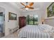 Bedroom with a large window, wardrobe, and ceiling fan, offering comfort and a tranquil view of the outdoors at 11611 Callisia Dr, Odessa, FL 33556