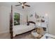 This bedroom features a four poster bed, ceiling fan and a bright window at 11611 Callisia Dr, Odessa, FL 33556
