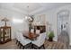 Elegant dining room with a large wood table, six chairs, and stylish chandelier, perfect for entertaining at 11611 Callisia Dr, Odessa, FL 33556