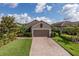 Charming home featuring a brick driveway, manicured lawn, and lush landscaping at 11611 Callisia Dr, Odessa, FL 33556