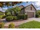 Beautiful single-story home featuring a lush landscaped yard and brick paver driveway at 11611 Callisia Dr, Odessa, FL 33556