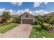 Charming home featuring a brick driveway, a two-car garage, and manicured landscaping at 11611 Callisia Dr, Odessa, FL 33556