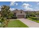 Charming home featuring a brick driveway, a two-car garage, and manicured landscaping at 11611 Callisia Dr, Odessa, FL 33556