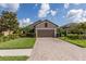 Charming home featuring a brick driveway, a two-car garage, and manicured landscaping at 11611 Callisia Dr, Odessa, FL 33556