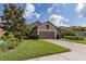 Charming home featuring a brick driveway, a two-car garage, and manicured landscaping at 11611 Callisia Dr, Odessa, FL 33556