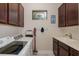 Bright laundry room with overhead cabinets, window, washer, dryer, and sink at 11611 Callisia Dr, Odessa, FL 33556