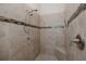 This tiled shower stall features a bench and decorative band tile for a modern and stylish look at 11611 Callisia Dr, Odessa, FL 33556