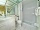 Modern bathroom with tiled floor, shower, vanity, and a ceiling with unique painted tiles at 11911 Bayonet Ln, New Port Richey, FL 34654