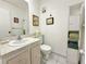 Clean bathroom featuring a vanity with sink, toilet, and storage shelves at 11911 Bayonet Ln, New Port Richey, FL 34654