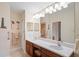 Well-lit bathroom with double sinks, a large mirror, and accessible features at 12071 Wexford Blvd, Spring Hill, FL 34609
