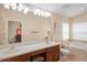 Bathroom featuring double sink vanity, soaking tub, and a glimpse into the connected bedroom at 12071 Wexford Blvd, Spring Hill, FL 34609