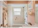 Bright bathroom with a window over tub, toilet, and towel rack at 12071 Wexford Blvd, Spring Hill, FL 34609