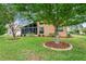 Rear of home featuring a screened lanai, well maintained lawn and shrubbery, with two young trees at 12071 Wexford Blvd, Spring Hill, FL 34609