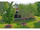 Rear of home featuring a screened lanai, well maintained lawn and shrubbery, with two young trees at 12071 Wexford Blvd, Spring Hill, FL 34609