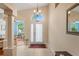 Bright foyer features tiled floors, chandelier and front door with glass features at 12071 Wexford Blvd, Spring Hill, FL 34609