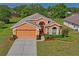 Inviting single-story home with well-maintained landscaping, a two-car garage, and a paved driveway at 12071 Wexford Blvd, Spring Hill, FL 34609