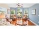 Inviting living room featuring large windows, ceiling fan, and beautiful hardwood flooring at 12071 Wexford Blvd, Spring Hill, FL 34609