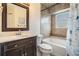 Well-lit bathroom featuring a shower-tub combo, vanity with dark wood cabinets, and decorative mirror at 1222 Starboard Ky, Tarpon Springs, FL 34689