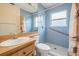 Bathroom with blue tile, a walk-in shower with a safety bar, and a light wood vanity at 1222 Starboard Ky, Tarpon Springs, FL 34689