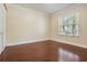 Bedroom with wood-look flooring, neutral walls, a window overlooking the neighborhood, and closet at 1222 Starboard Ky, Tarpon Springs, FL 34689