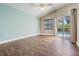A serene bedroom featuring wood-look floors and a sliding glass door overlooking the pool area at 1222 Starboard Ky, Tarpon Springs, FL 34689