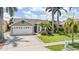 Charming single-story home with a well-manicured lawn and mature palm trees enhancing its curb appeal at 1222 Starboard Ky, Tarpon Springs, FL 34689