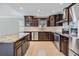 Modern kitchen featuring stainless steel appliances, dark wood cabinets, and granite countertops at 1222 Starboard Ky, Tarpon Springs, FL 34689