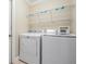 Laundry room with a white washer and dryer, as well as wire rack shelving for extra storage at 1222 Starboard Ky, Tarpon Springs, FL 34689