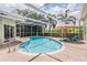 Inviting screened-in pool area with brick pavers, ample seating, and lush landscaping for privacy at 1222 Starboard Ky, Tarpon Springs, FL 34689