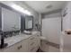 Bright bathroom featuring a double vanity, shower with curtain, and updated fixtures and finishes at 12408 Country White Cir, Tampa, FL 33635