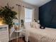 Cozy bedroom with stylish navy blue accent wall, comfortable bed, side table and indoor plants at 12408 Country White Cir, Tampa, FL 33635