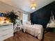 Bedroom with a stylish navy blue accent wall, comfortable bed, a hanging chair and indoor plants at 12408 Country White Cir, Tampa, FL 33635
