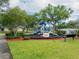 Community playground with green grass, mature trees, and a bench at 12408 Country White Cir, Tampa, FL 33635