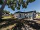 View of the backyard, featuring the back of the home with a enclosed patio and grassy area at 1249 Honor Dr, Holiday, FL 34690
