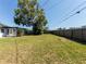 Expansive backyard with a mature shade tree and partial fencing, ideal for outdoor activities at 1249 Honor Dr, Holiday, FL 34690