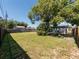 Spacious backyard with partial tree shade, enclosed by a wooden fence, offering a private outdoor space at 1249 Honor Dr, Holiday, FL 34690
