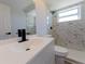 Modern bathroom features marble tile shower, white vanity with black faucet, and updated fixtures, exuding style and comfort at 1249 Honor Dr, Holiday, FL 34690