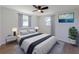 Cozy bedroom with neutral tones, complemented by a ceiling fan, two windows with curtain and ample natural light at 1249 Honor Dr, Holiday, FL 34690