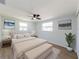 Bedroom features a ceiling fan, wood floors, two windows with curtain and ample natural light at 1249 Honor Dr, Holiday, FL 34690