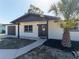 Beautifully updated single-story home with a welcoming entrance, dark accents, and lush landscaping at 1249 Honor Dr, Holiday, FL 34690