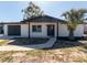Charming single-story home with a freshly painted exterior, dark trim, and new landscaping at 1249 Honor Dr, Holiday, FL 34690