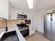 Beautifully remodeled kitchen with white cabinets, stainless steel appliances, and modern lighting at 1249 Honor Dr, Holiday, FL 34690