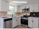 Modern kitchen featuring white cabinetry, stainless steel appliances, and stylish countertops at 1249 Honor Dr, Holiday, FL 34690