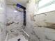 Modern shower featuring elegant marble tile and a luxurious, wall-mounted multi-function shower system at 1249 Honor Dr, Holiday, FL 34690