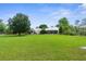 Expansive backyard features a lush lawn, mature trees, and a charming home with a covered patio for outdoor living at 1253 Culbreath Rd, Brooksville, FL 34602